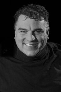 Black-and-white portrait of Eric Berlin smiling — self-portrait